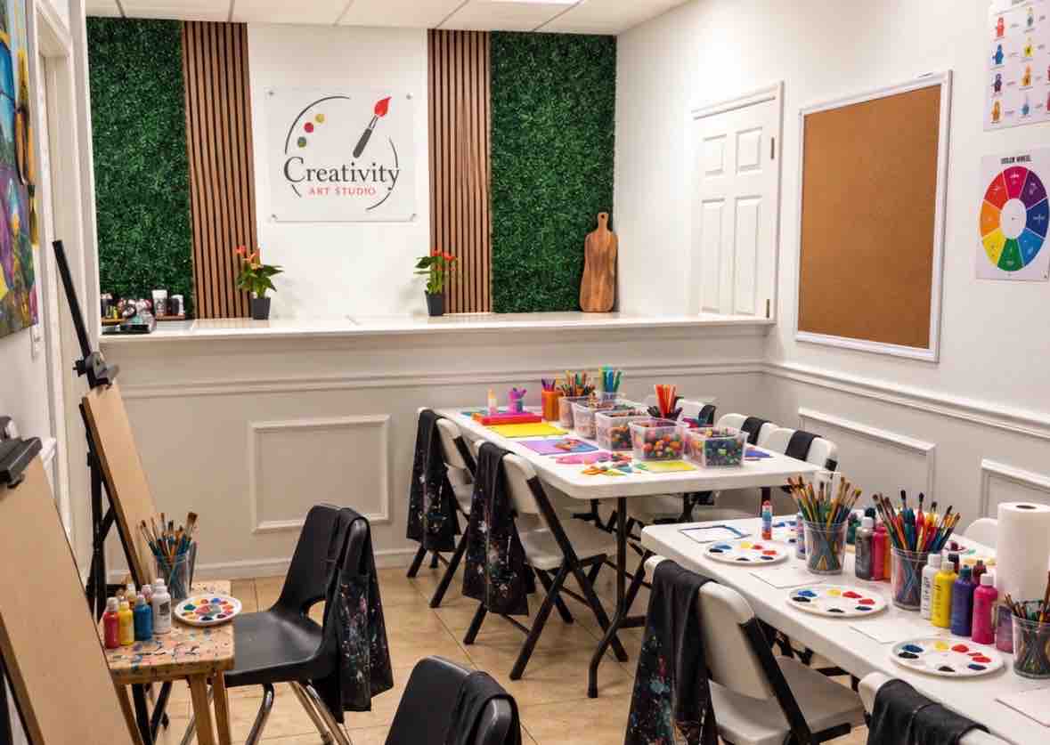A warm, light-filled Creativity Art Studio with easels, paints, and brushes
